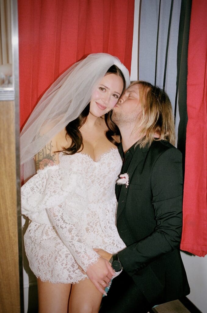 portrait of the groom kissing the bride on the cheek
