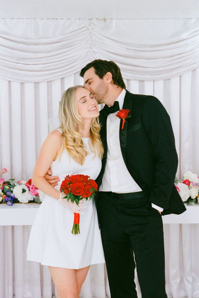 groom kissing the bride on the cheek