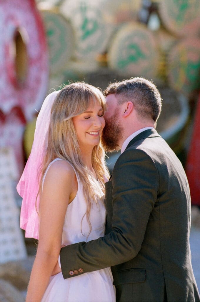 groom kissing the bride on the cheek