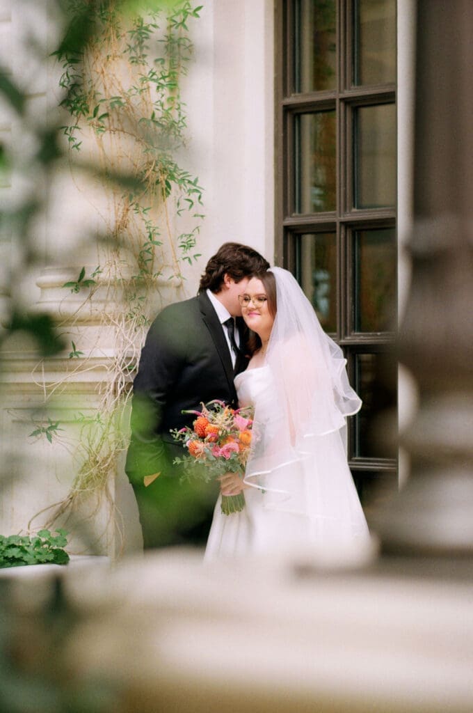groom kissing the bride on the cheek