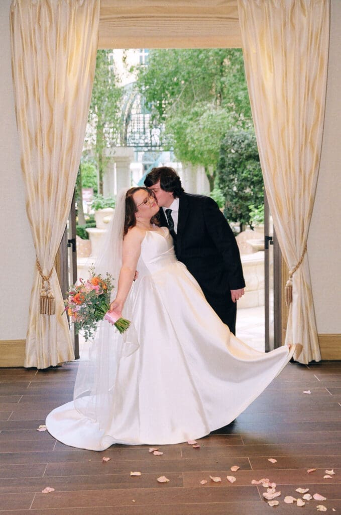 groom kissing the bride on the cheek